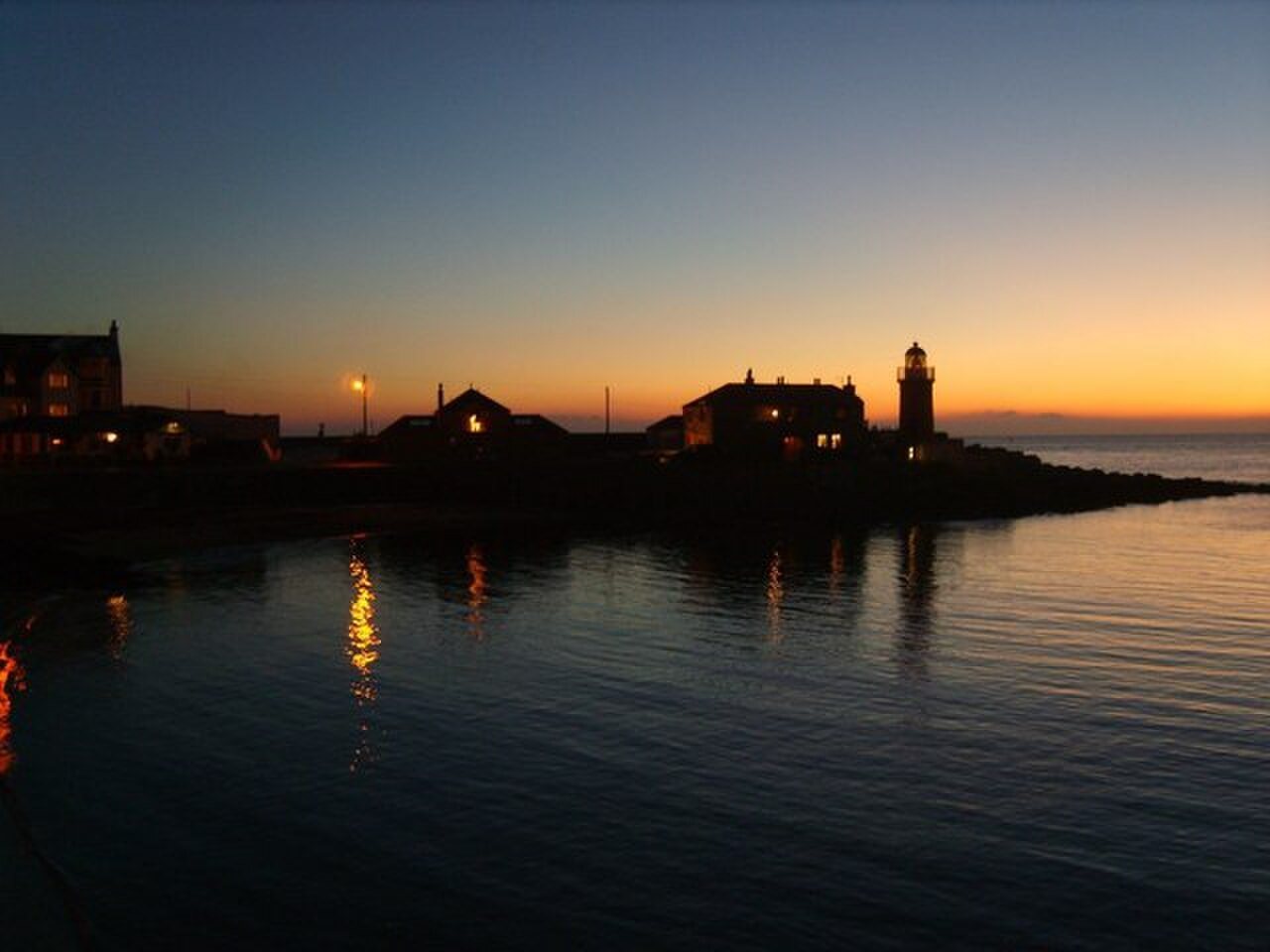 Sunset behind the harbour lighthouse at Portpatrick.