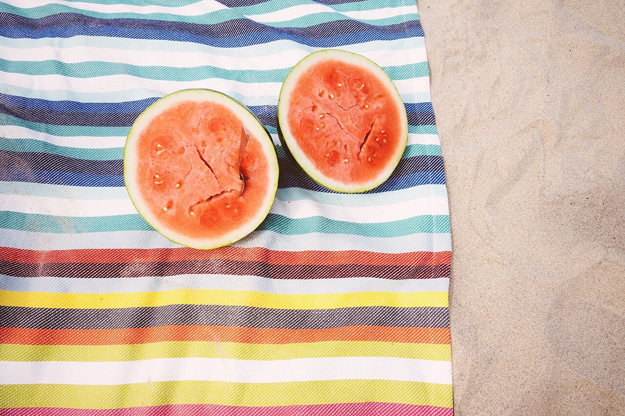 Watermelon on a beach picnic cloth, shown as a picnic illustration.